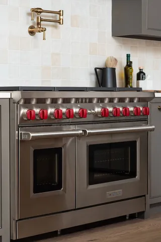 a kitchen with a stove a sink and a window