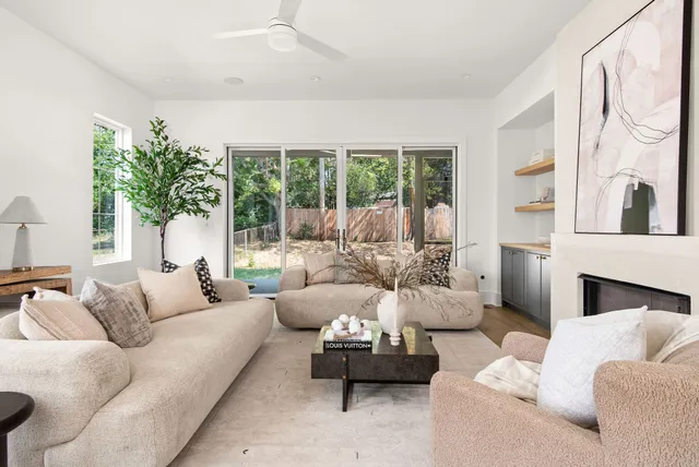 a living room with furniture fireplace and a large window