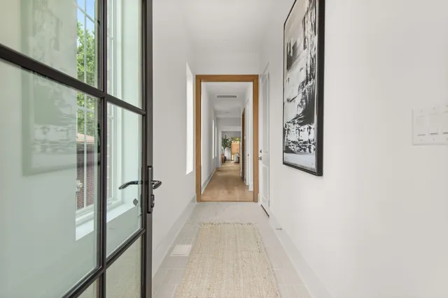 a view of a hallway with wooden floor and a bathroom