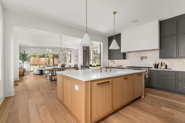 a kitchen with kitchen island granite countertop a sink counter top space and stainless steel appliances