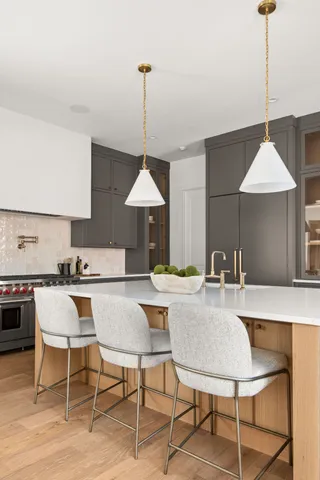a kitchen with a table chairs stove and wooden floor