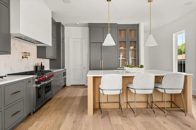 a kitchen with stainless steel appliances a stove and white cabinets