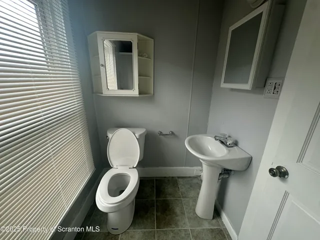 a white toilet sitting next to a bathroom sink