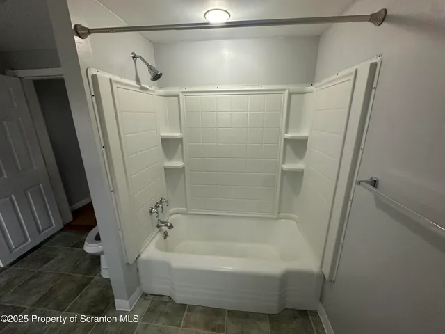 a bathroom with a bathtub and a shower