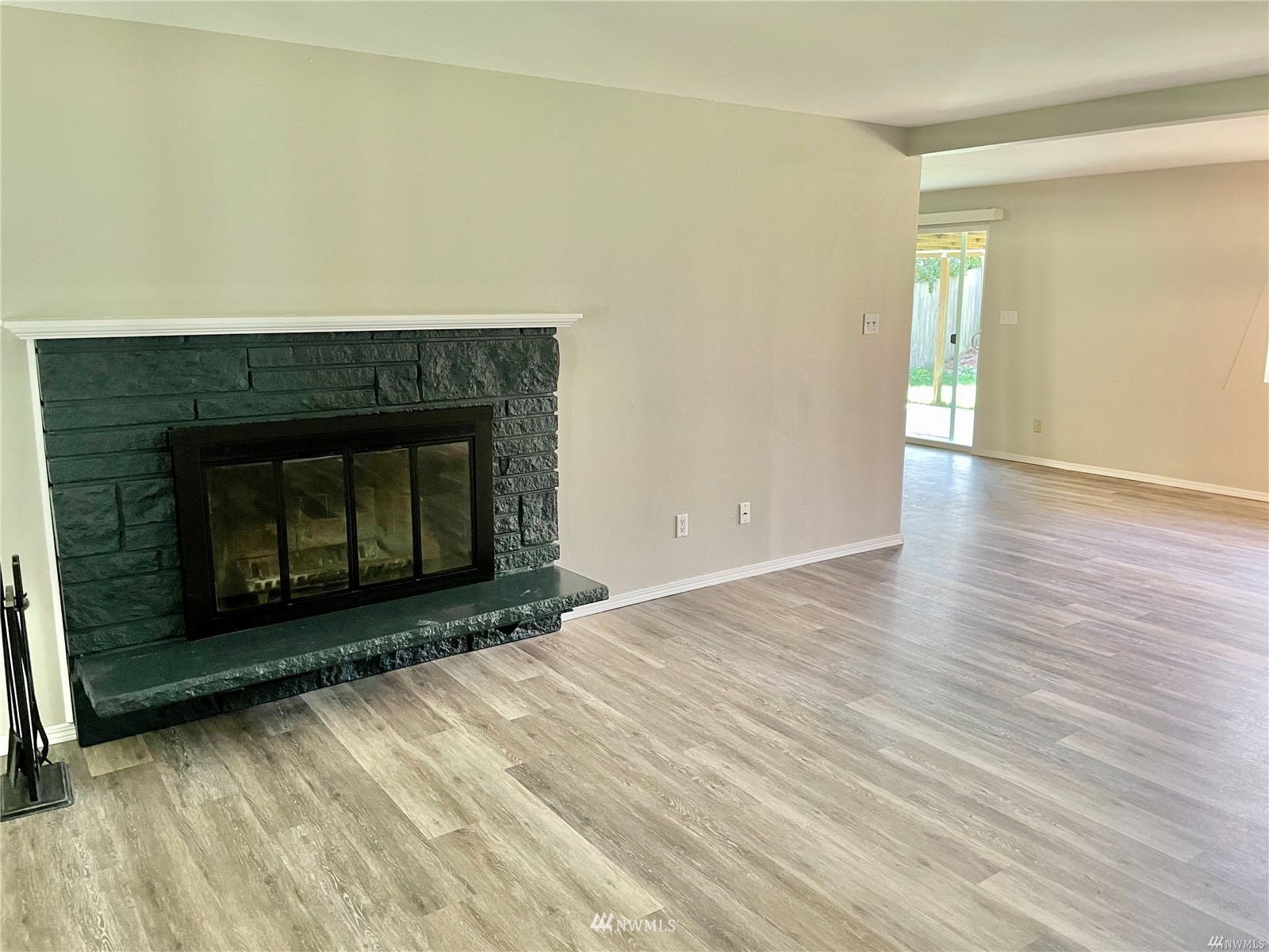 1067 Anacortes Avenue Northeast Renton, WA 98059 - Photo 5 of 18 a view of an empty room with wooden floor and a fireplace