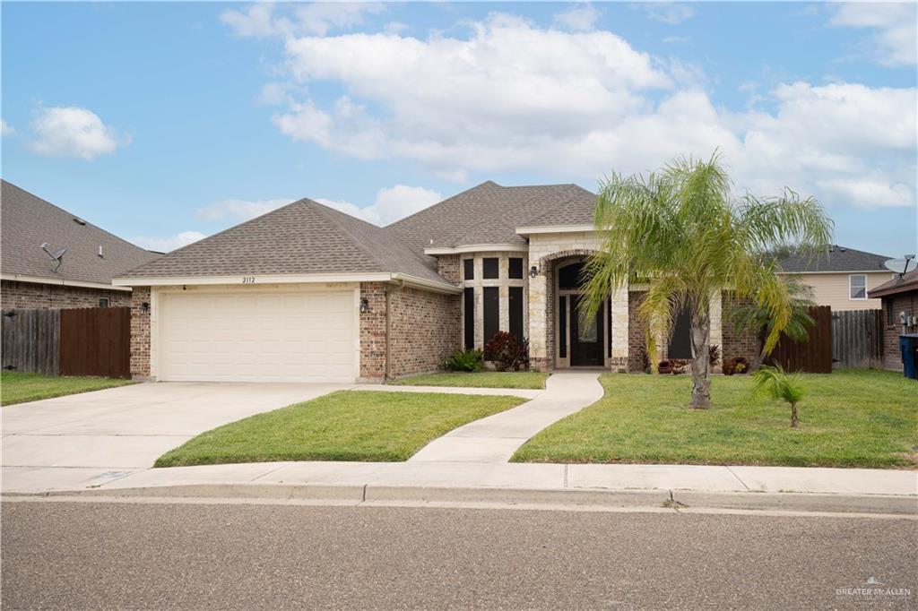 2112 Kilgore Avenue McAllen, TX 78504 - Photo 17 of 19 a front view of a house with a garden and trees