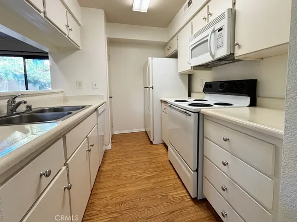 a kitchen with granite countertop a sink and a stove top oven