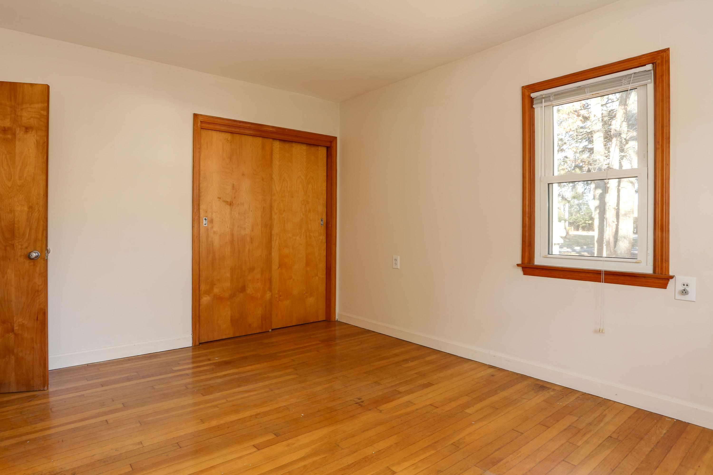 625 Poponessett Road Cotuit, MA 02635 - Photo 13 of 32 an empty room with wooden floor and windows