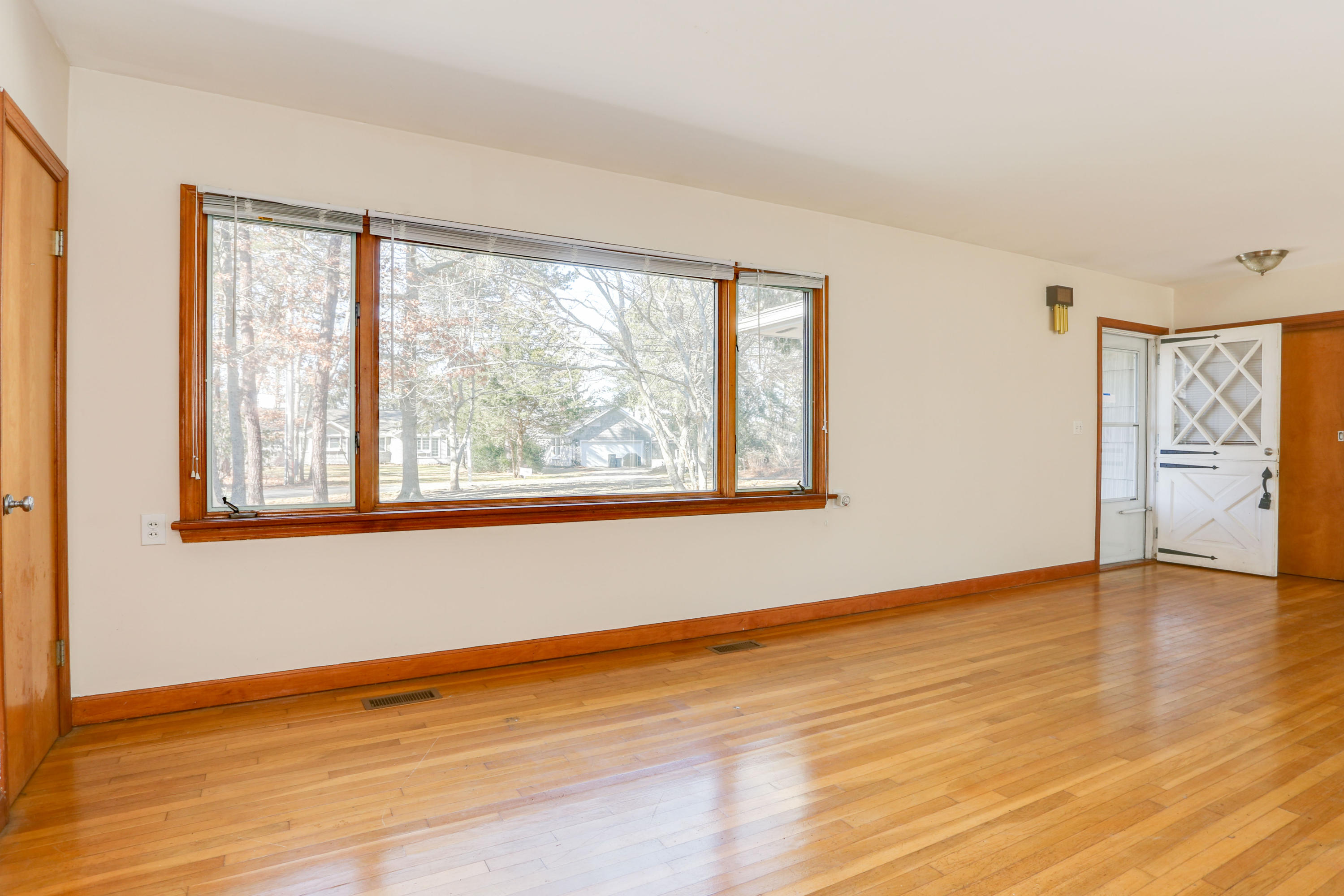 625 Poponessett Road Cotuit, MA 02635 - Photo 3 of 32 a view of an empty room with window and wooden floor