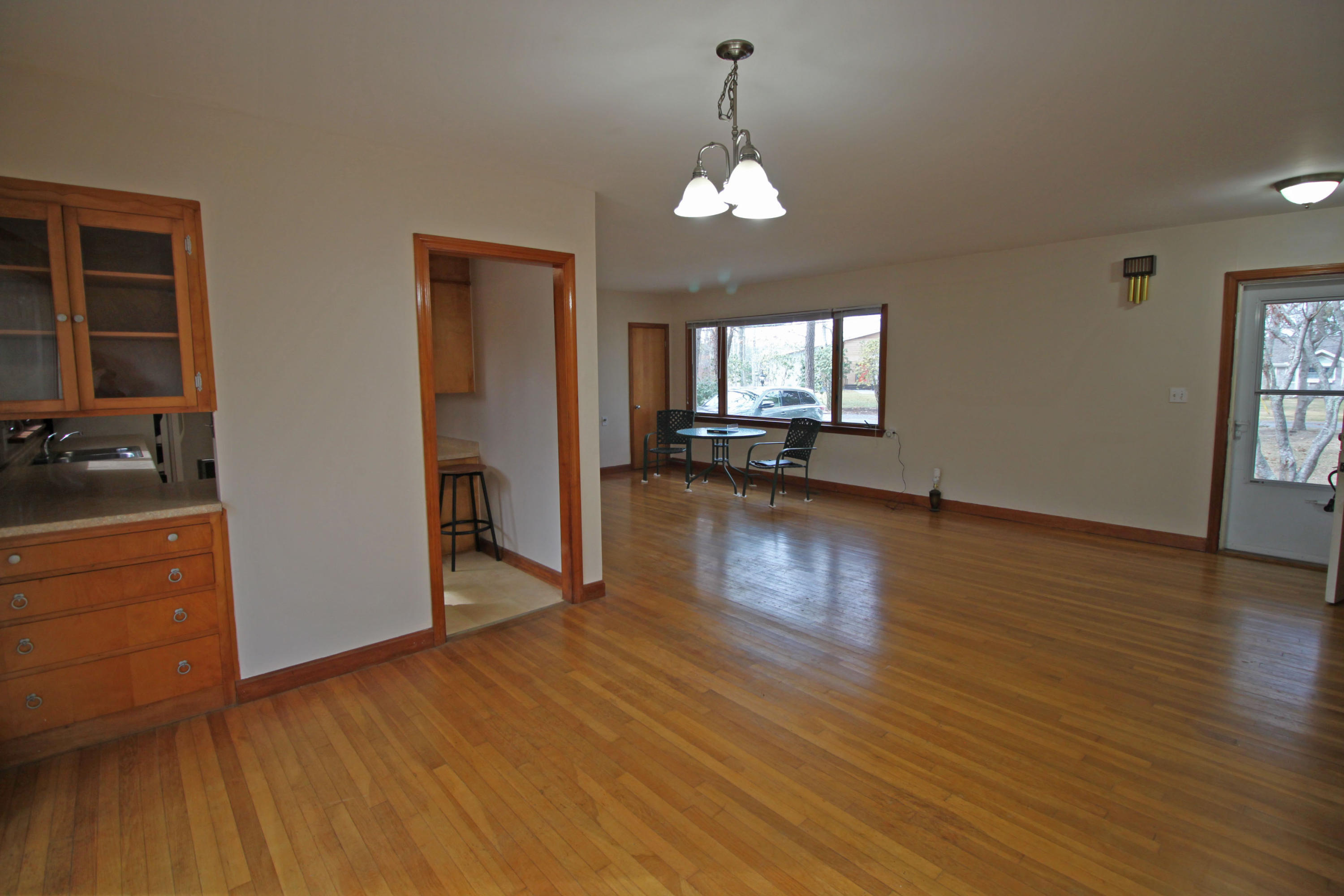 625 Poponessett Road Cotuit, MA 02635 - Photo 7 of 32 an empty room with wooden floor and windows
