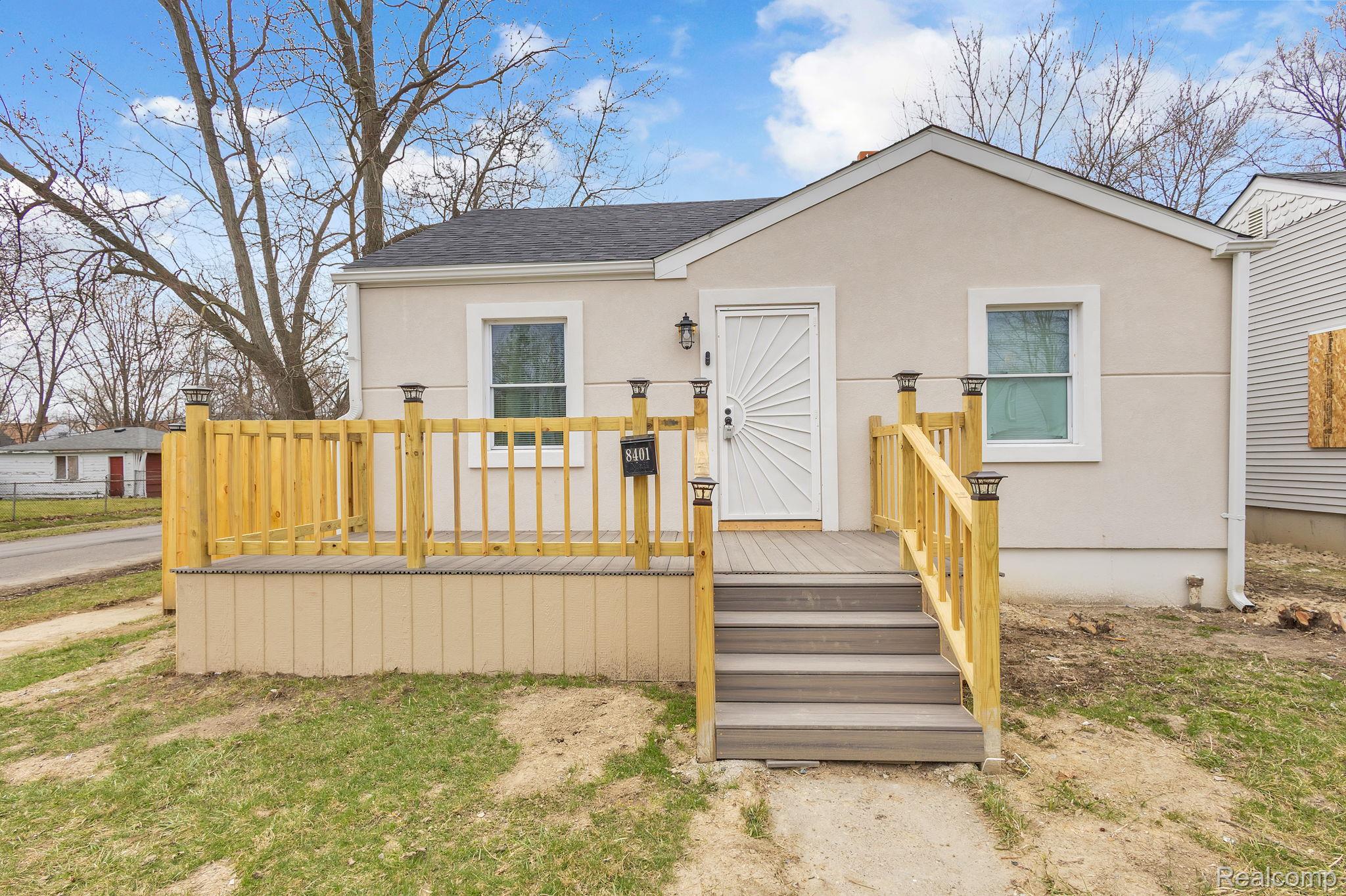 8401 Fielding Street Detroit, MI 48228 - Photo 2 of 34 Bungalow-style home with a wooden deck, stucco siding, and a shingled roof