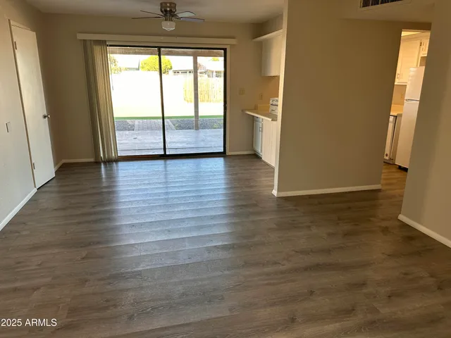 an empty room with windows and fan