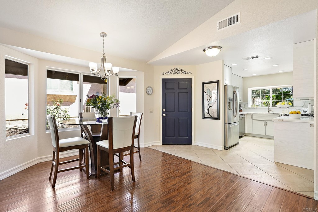 a view of a dining room and livingroom with furniture wooden floor a chandelier