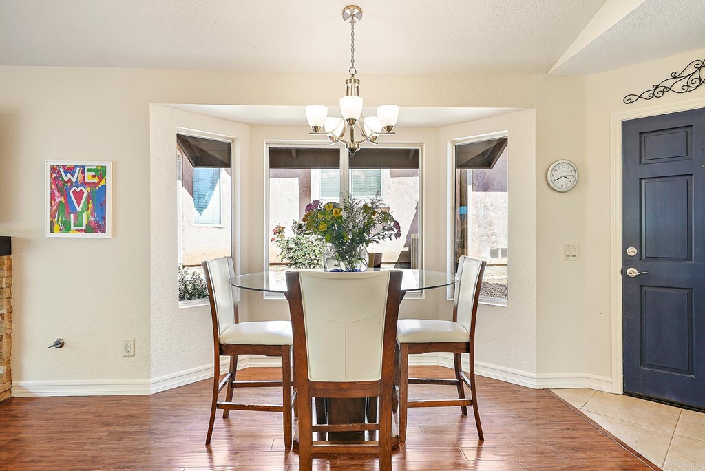 1848 Loreto Glen Escondido, CA 92027 - Photo 13 of 43 a dining room with furniture a chandelier and wooden floor