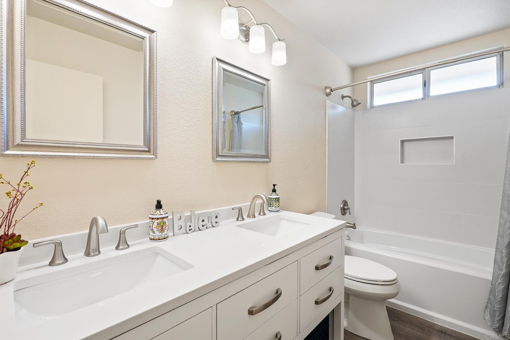 1848 Loreto Glen Escondido, CA 92027 - Photo 27 of 43 a bathroom with a double vanity sink toilet and a mirror