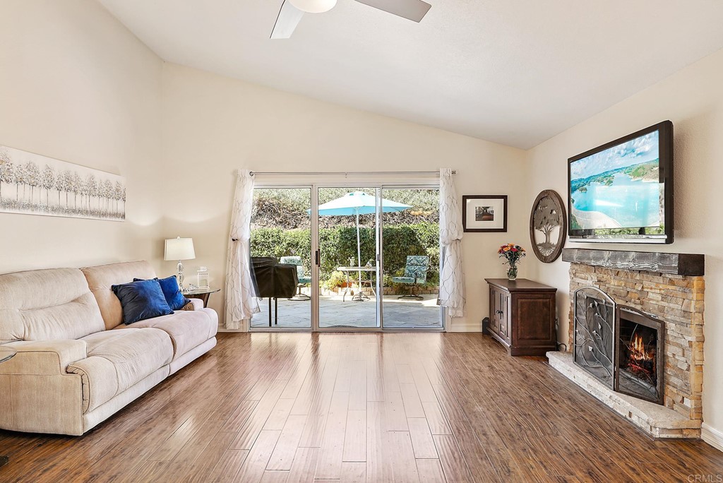 1848 Loreto Glen Escondido, CA 92027 - Photo 4 of 43 a living room with furniture a fireplace and a floor to ceiling window