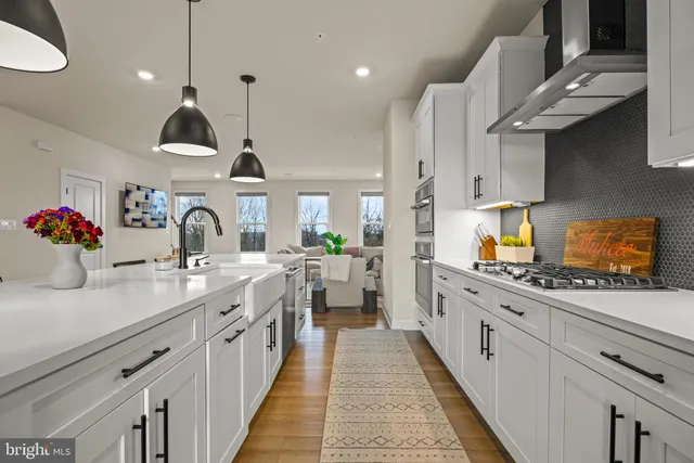 a open kitchen with stainless steel appliances granite countertop a stove a sink and a wooden floors