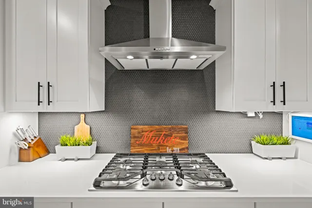 a kitchen with stainless steel appliances granite countertop a stove a sink and a white cabinets