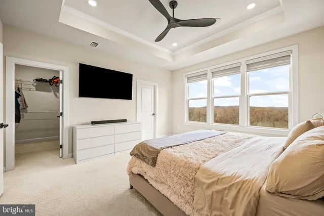 a bedroom with a large bed and a flat tv screen