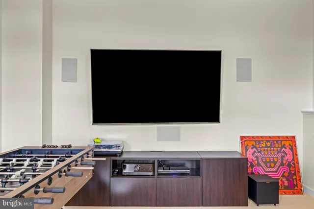 a living room with a flat screen tv and view of kitchen