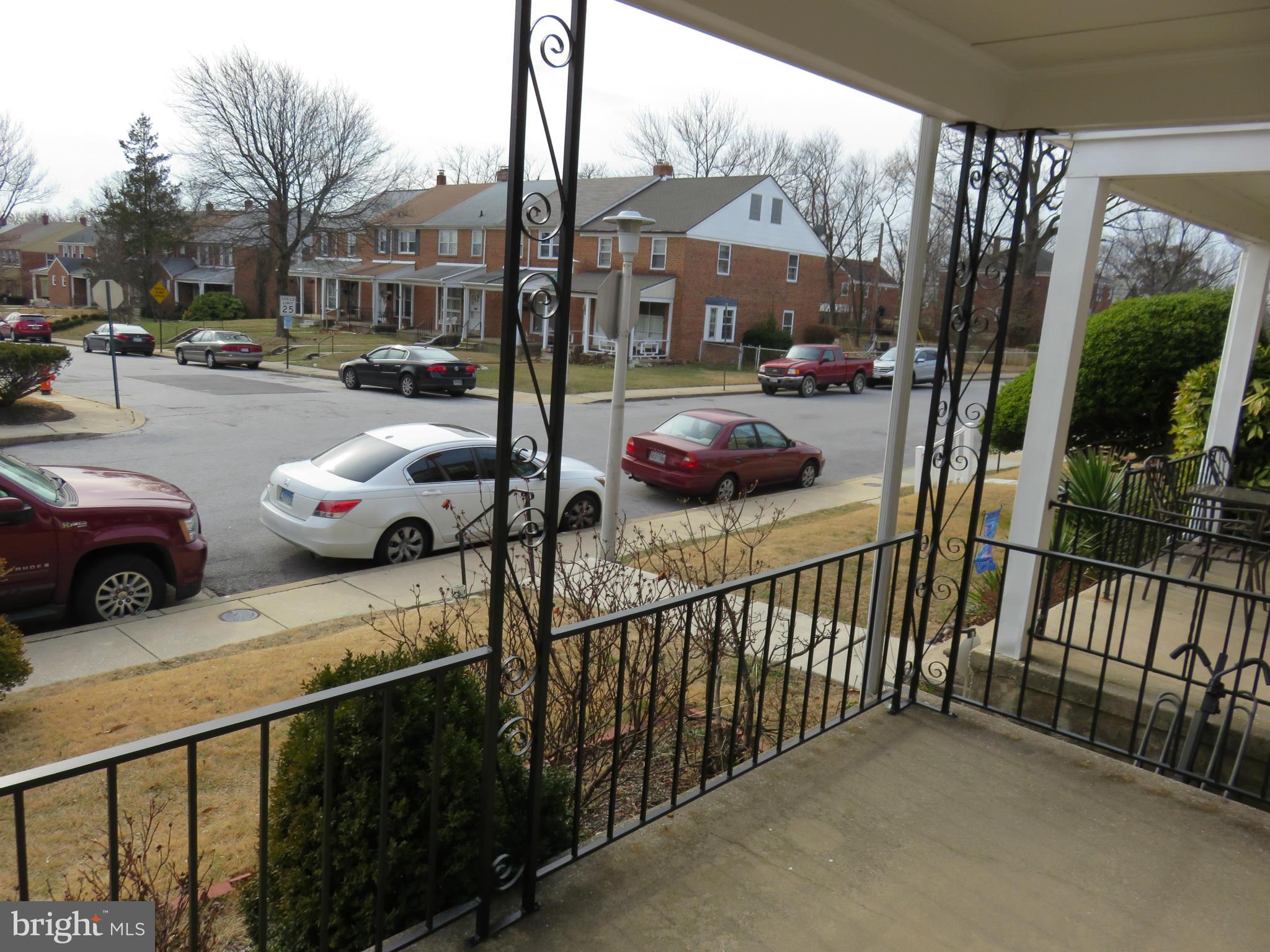 1132 Cedarcroft Road Baltimore, MD 21239 - Photo 14 of 16 a view of a porch with furniture and cars parked