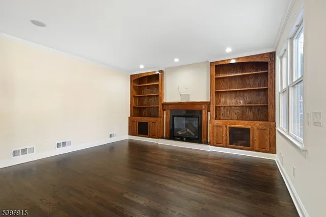 a view of an empty room with a fireplace and a window