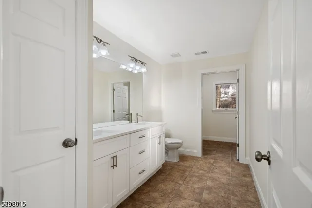 a spacious bathroom with a toilet sink and mirror