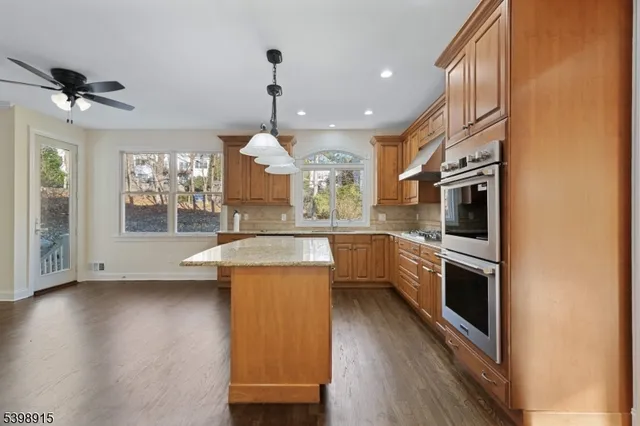a kitchen with stainless steel appliances granite countertop a sink a stove and a refrigerator