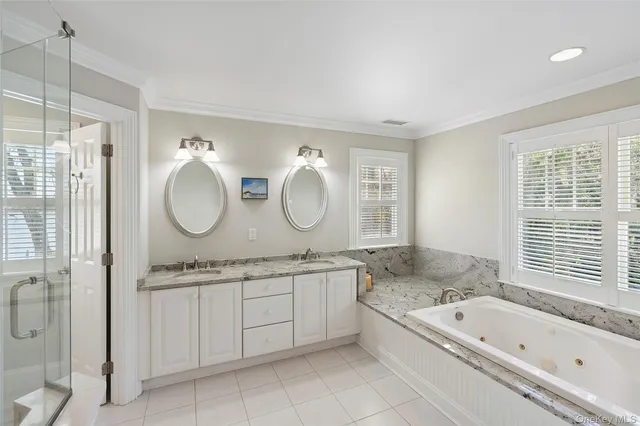 a bathroom with a granite countertop sink mirror vanity bathtub and shower
