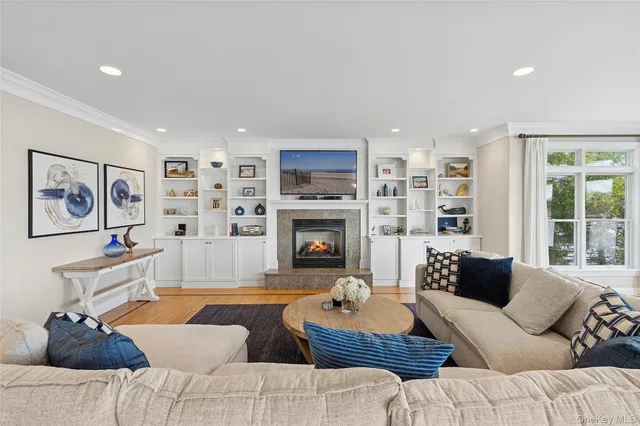 a living room with furniture fireplace and a large window