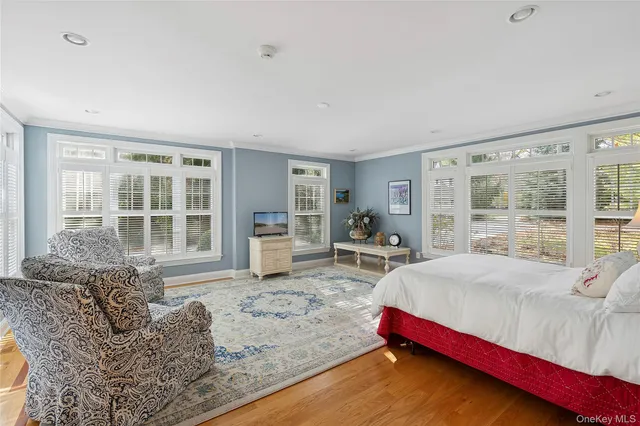 a bedroom with furniture and a large window