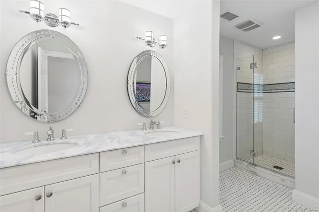 a bathroom with a granite countertop double vanity sink and a mirror