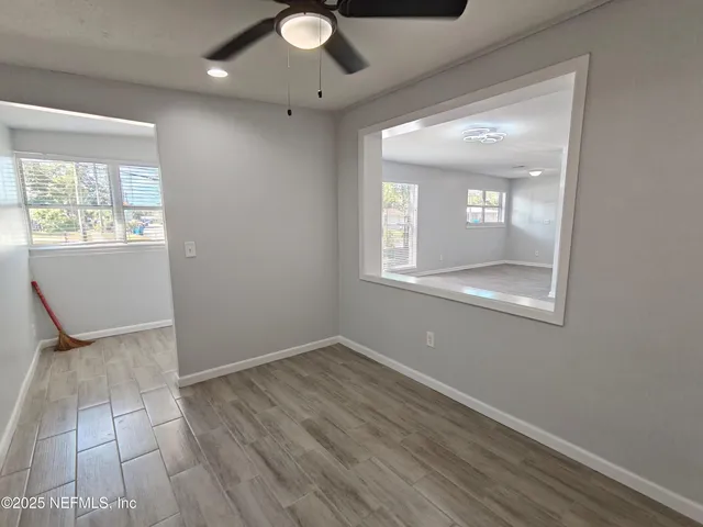 a view of an empty room with wooden floor