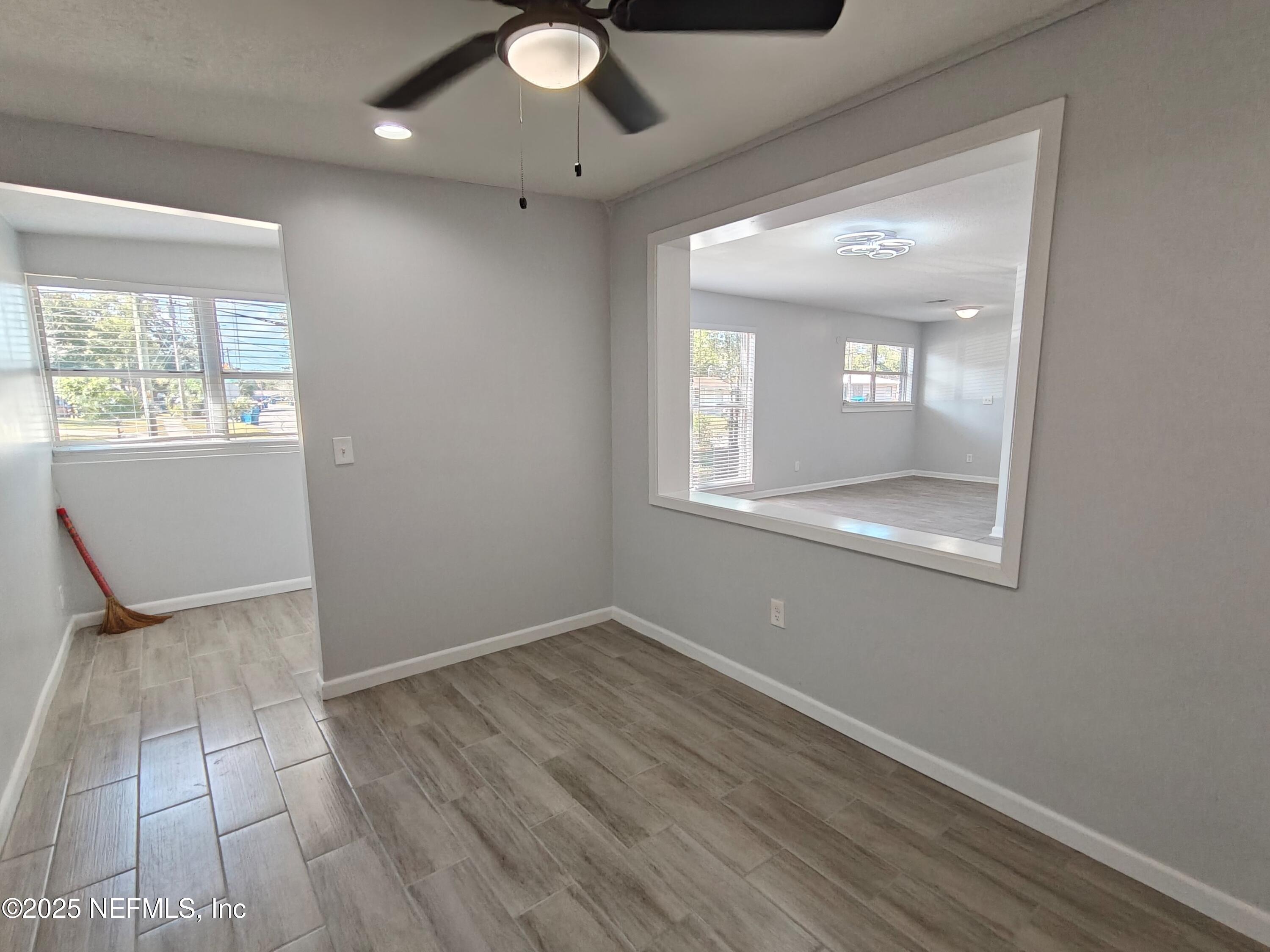 2921 Mansion Road Jacksonville, FL 32277 - Photo 11 of 40 an empty room with wooden floor and windows