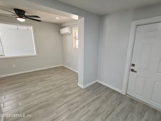 a view of an empty room with wooden floor