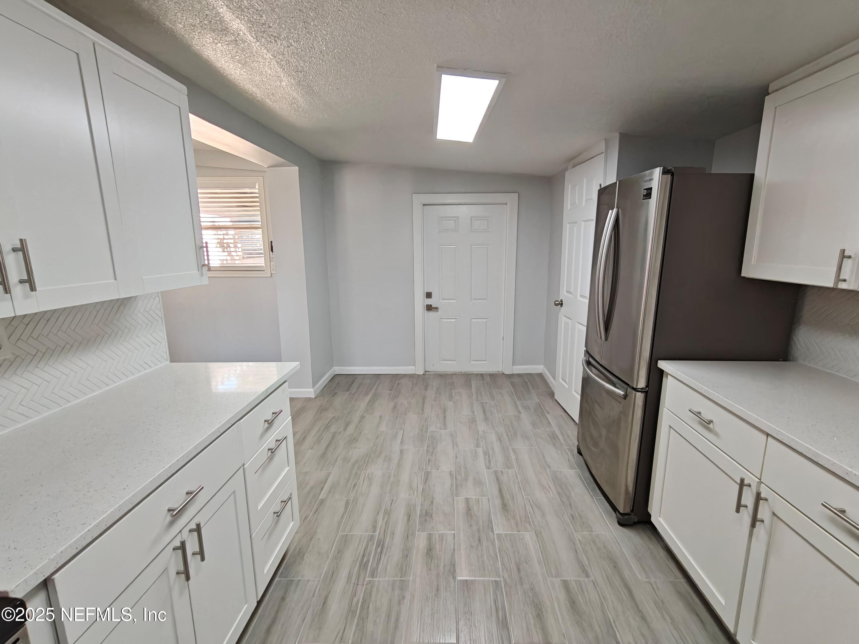 2921 Mansion Road Jacksonville, FL 32277 - Photo 19 of 40 a kitchen with a sink a refrigerator and wooden floor