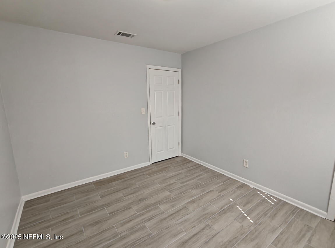 2921 Mansion Road Jacksonville, FL 32277 - Photo 24 of 40 a view of an empty room with wooden floor