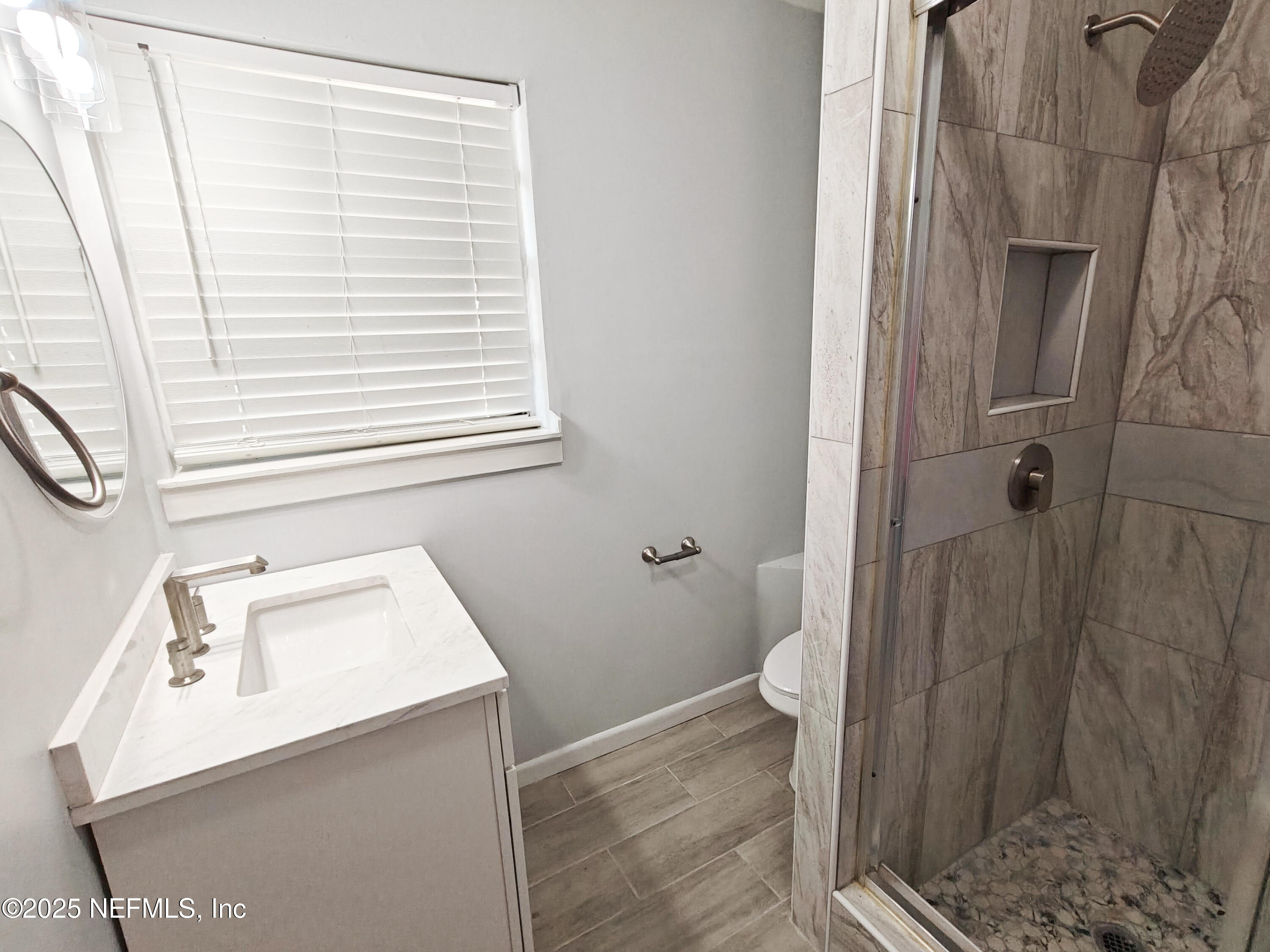 2921 Mansion Road Jacksonville, FL 32277 - Photo 26 of 40 a bathroom with a sink a toilet and shower