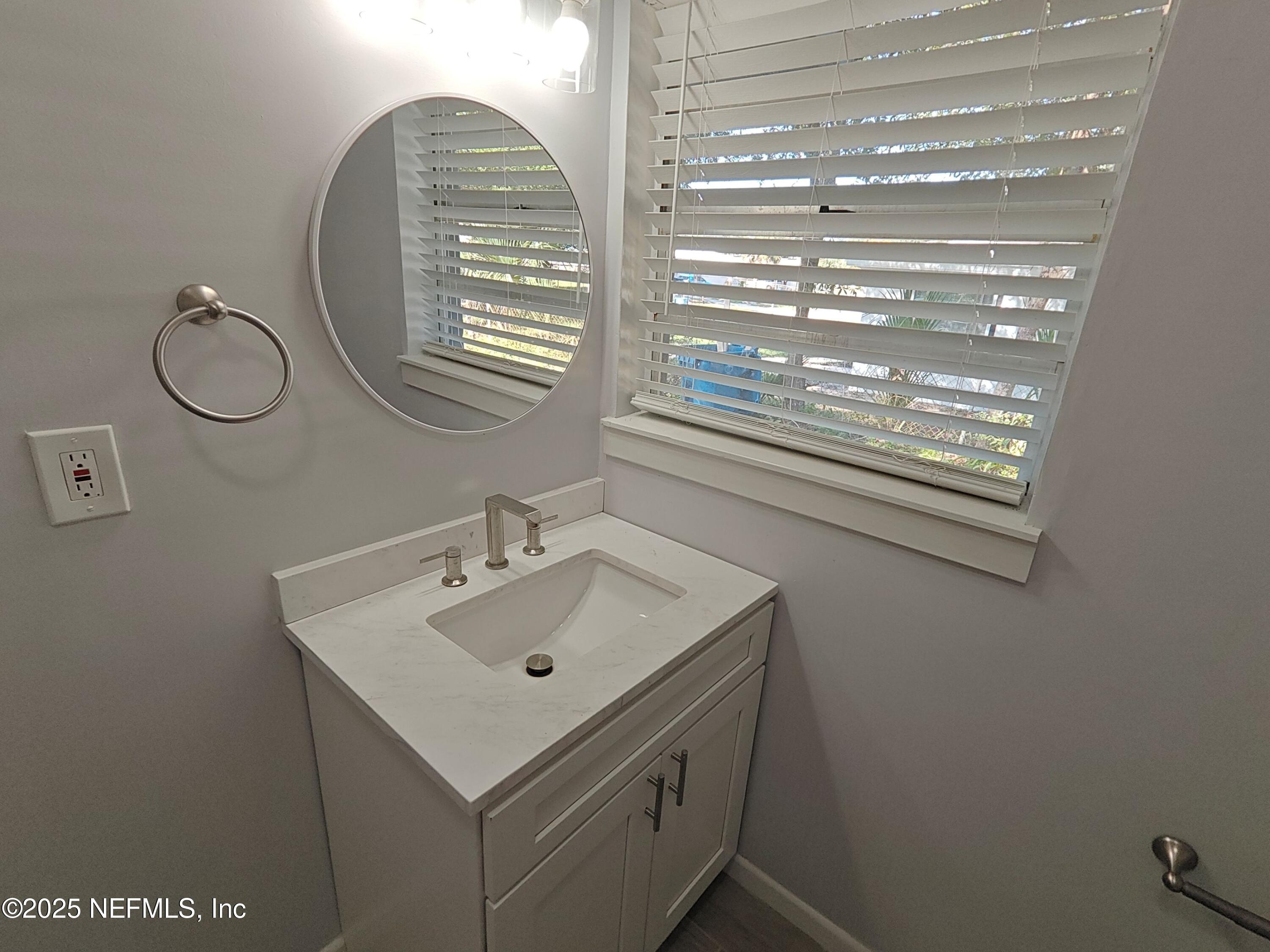 2921 Mansion Road Jacksonville, FL 32277 - Photo 33 of 40 a bathroom with a sink and a mirror