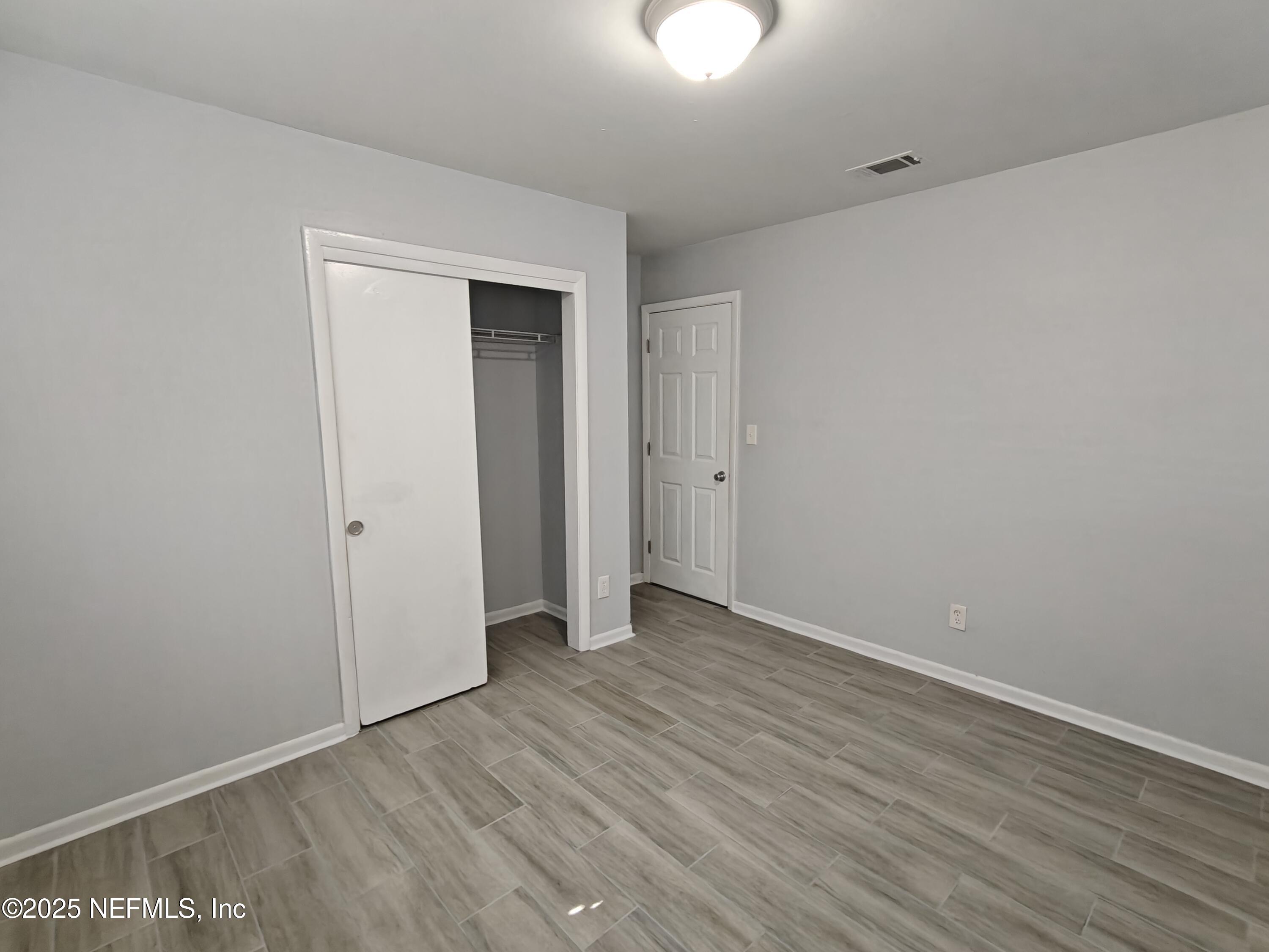 2921 Mansion Road Jacksonville, FL 32277 - Photo 34 of 40 a view of an empty room with wooden floor