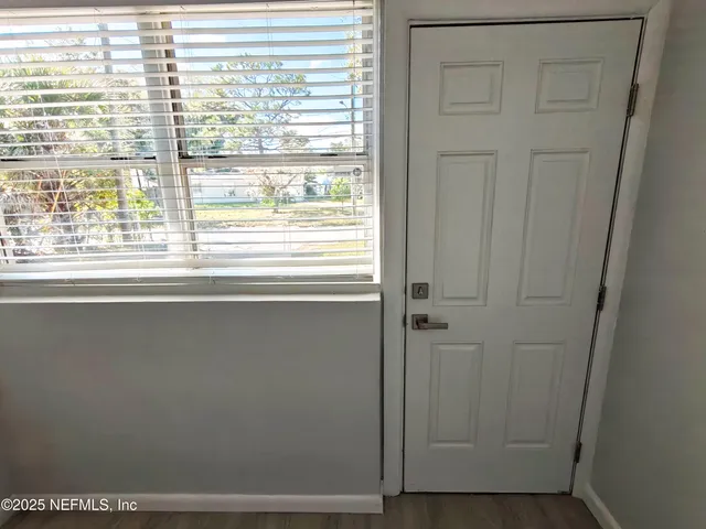 a view of a big room with wooden floor and windows