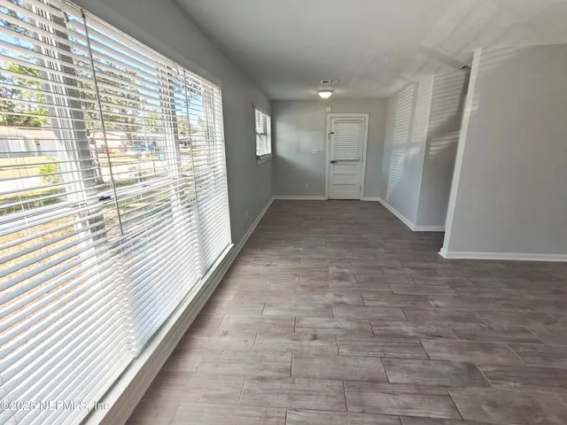 a kitchen with white cabinets appliances a sink and a window