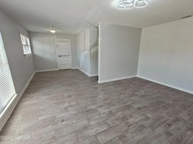 a kitchen with a refrigerator and white cabinets