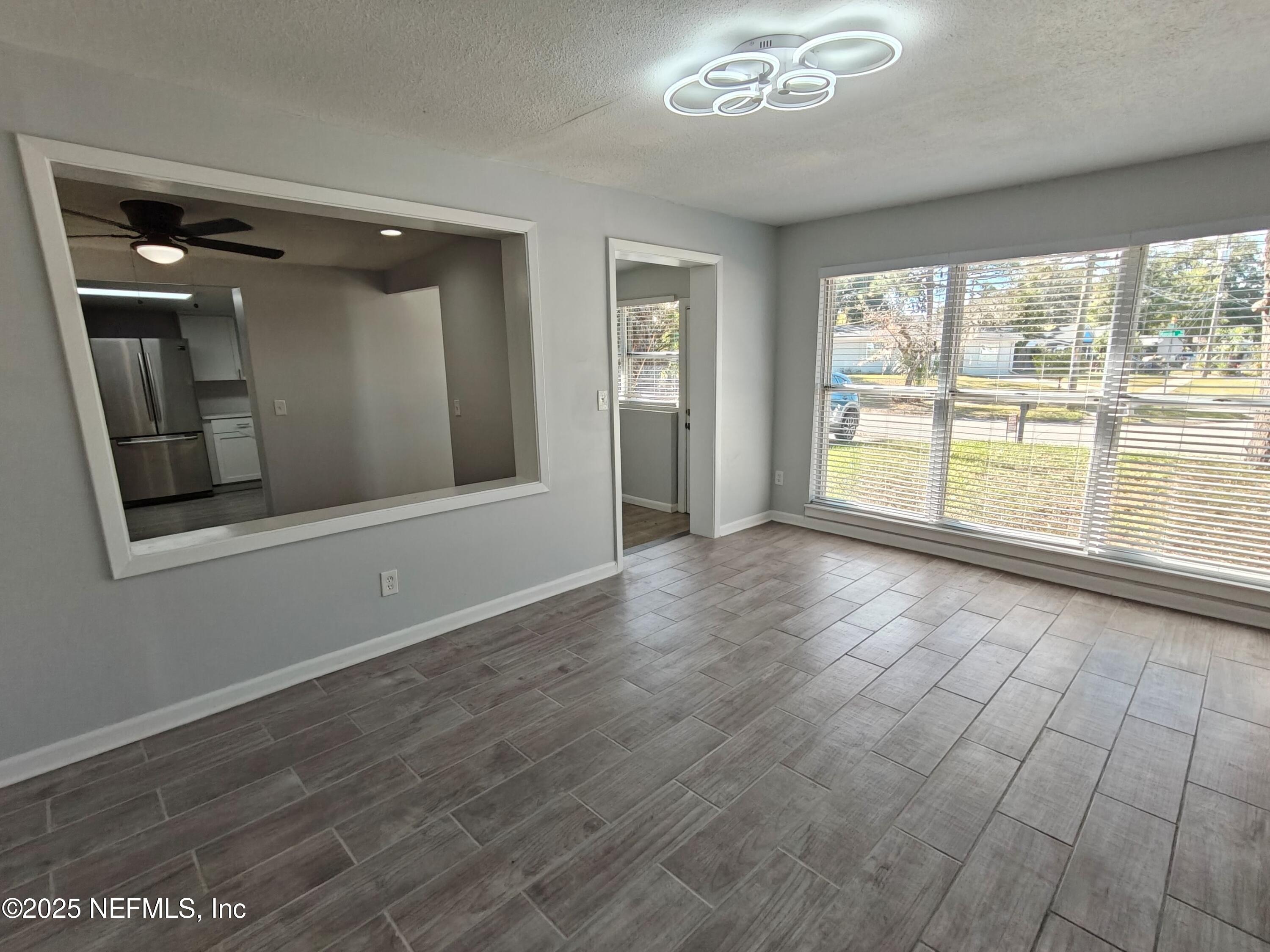 2921 Mansion Road Jacksonville, FL 32277 - Photo 9 of 40 wooden floor in an empty room with a window