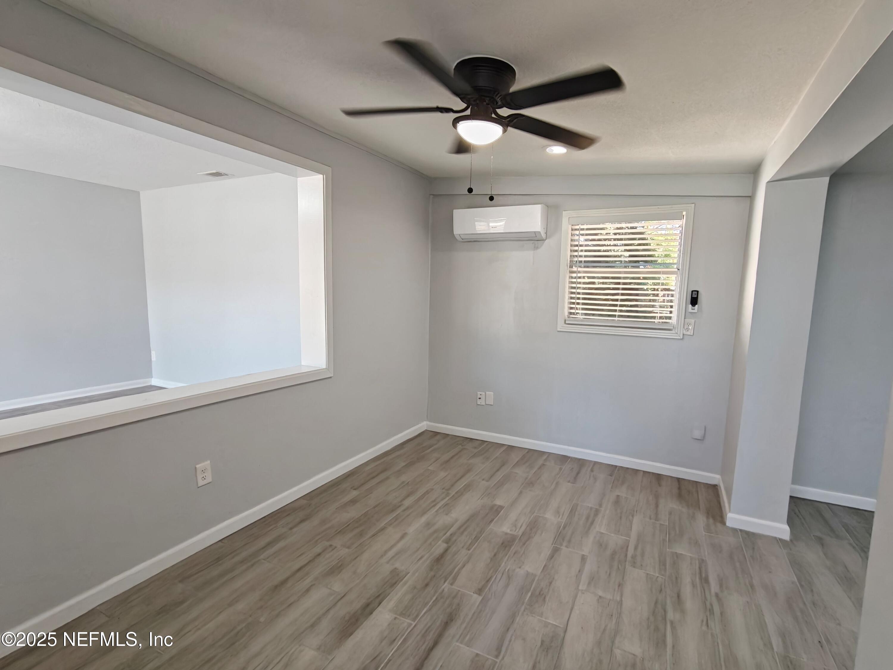 2921 Mansion Road Jacksonville, FL 32277 - Photo 10 of 40 a view of a big room with wooden floor and windows