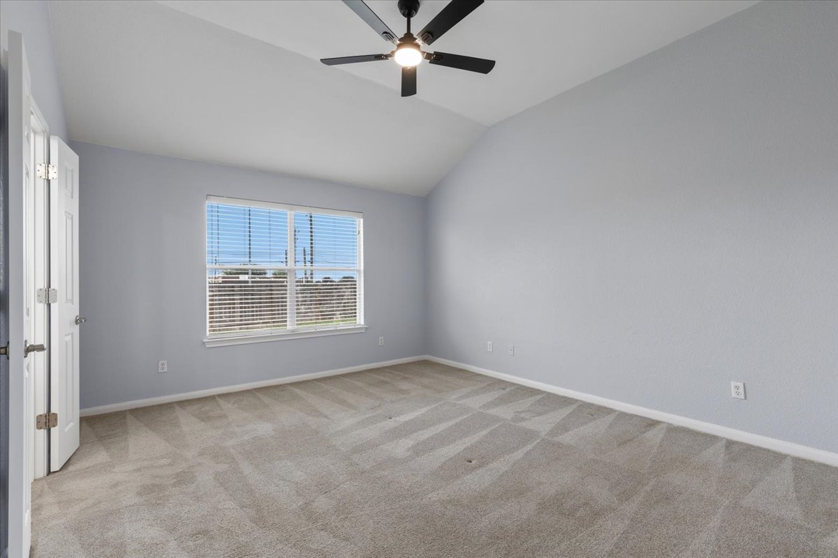 17812 Masi Loop Pflugerville, TX 78660 - Photo 19 of 38 Spacious room featuring vaulted ceilings, a large window with blinds, and a contemporary ceiling fan