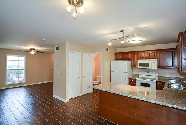 a open kitchen with stainless steel appliances granite countertop a refrigerator and a stove top oven