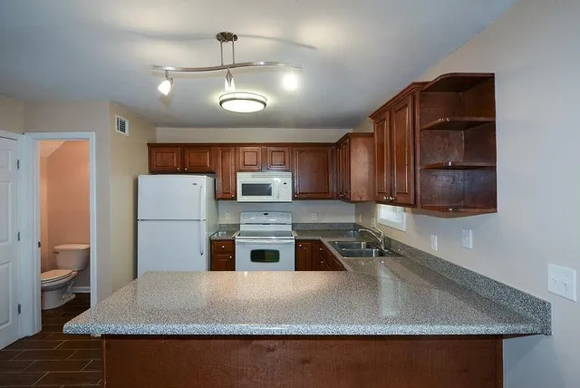 a kitchen with kitchen island a counter top space a sink stainless steel appliances and cabinets
