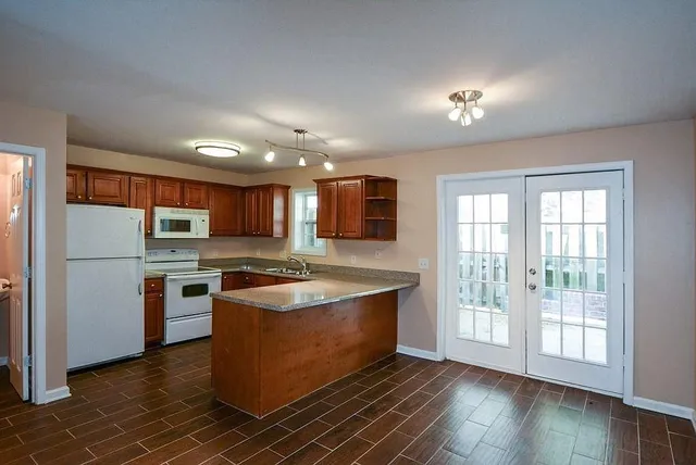 a kitchen with stainless steel appliances granite countertop a stove a sink and a refrigerator