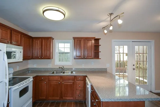 a kitchen with stainless steel appliances granite countertop a stove a sink and a microwave